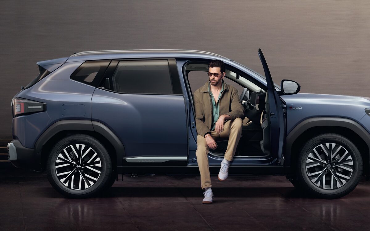 Nissan Tekton in blue-grey, side profile with a man sitting in the open front door