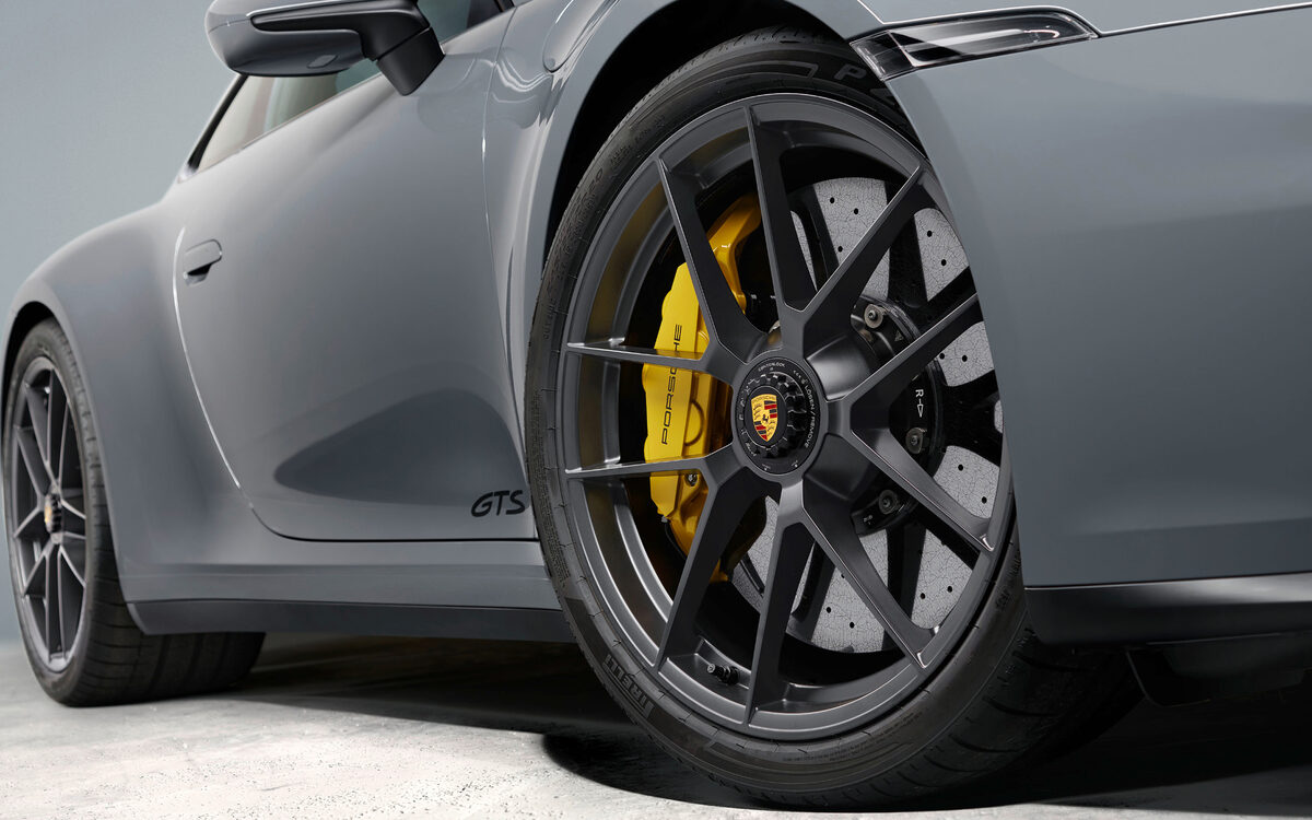 Close-up of a Porsche 911 GTS wheel with yellow brake caliper and GTS lettering on the door