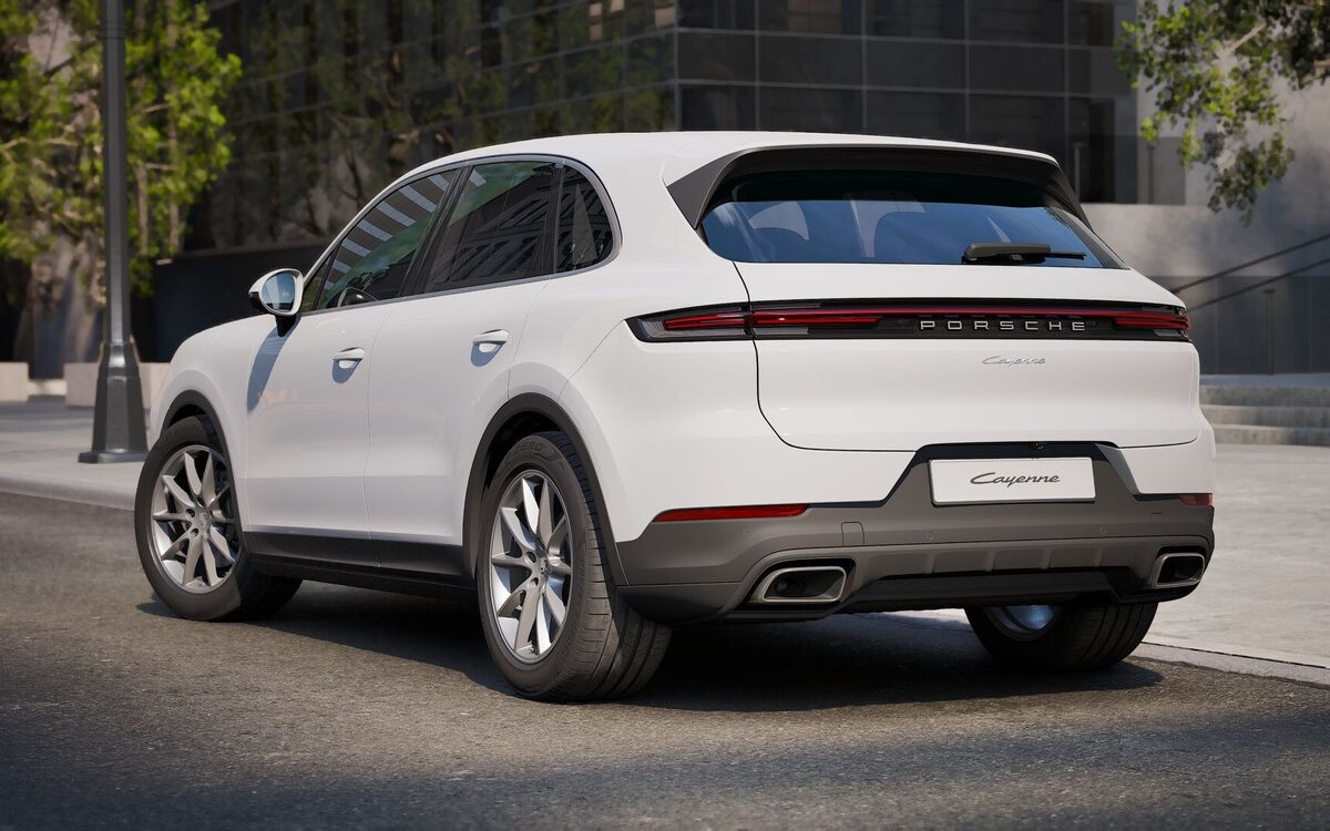 Porsche Cayenne in white seen from the rear three-quarter with the full-width light strip
