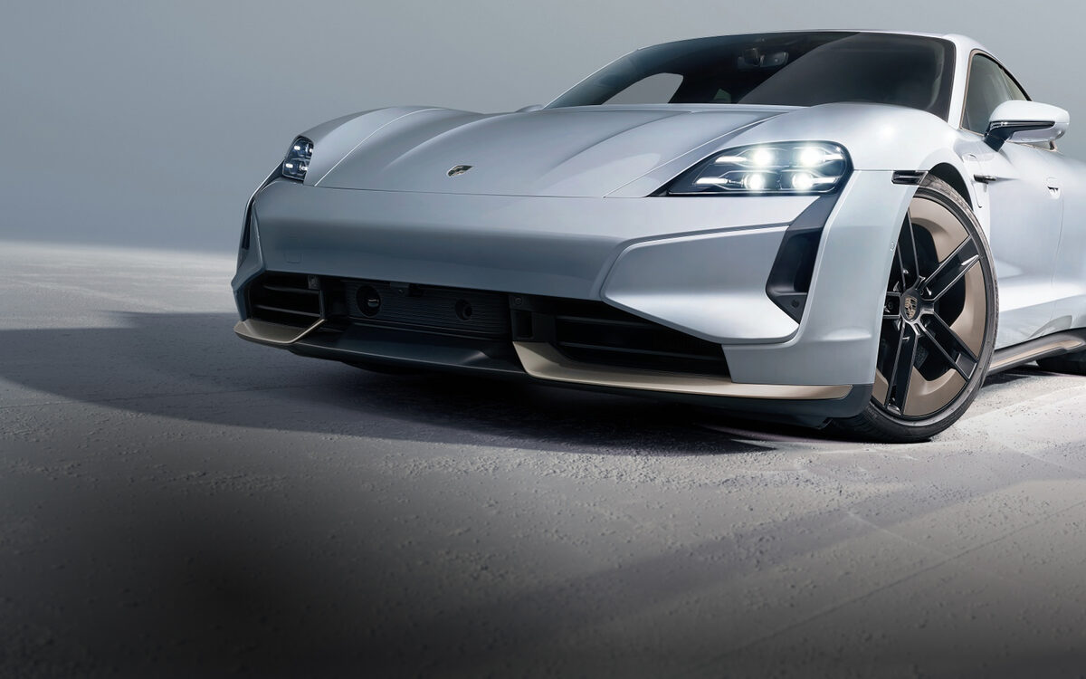 Porsche Taycan in silver, front three-quarter view in a grey studio