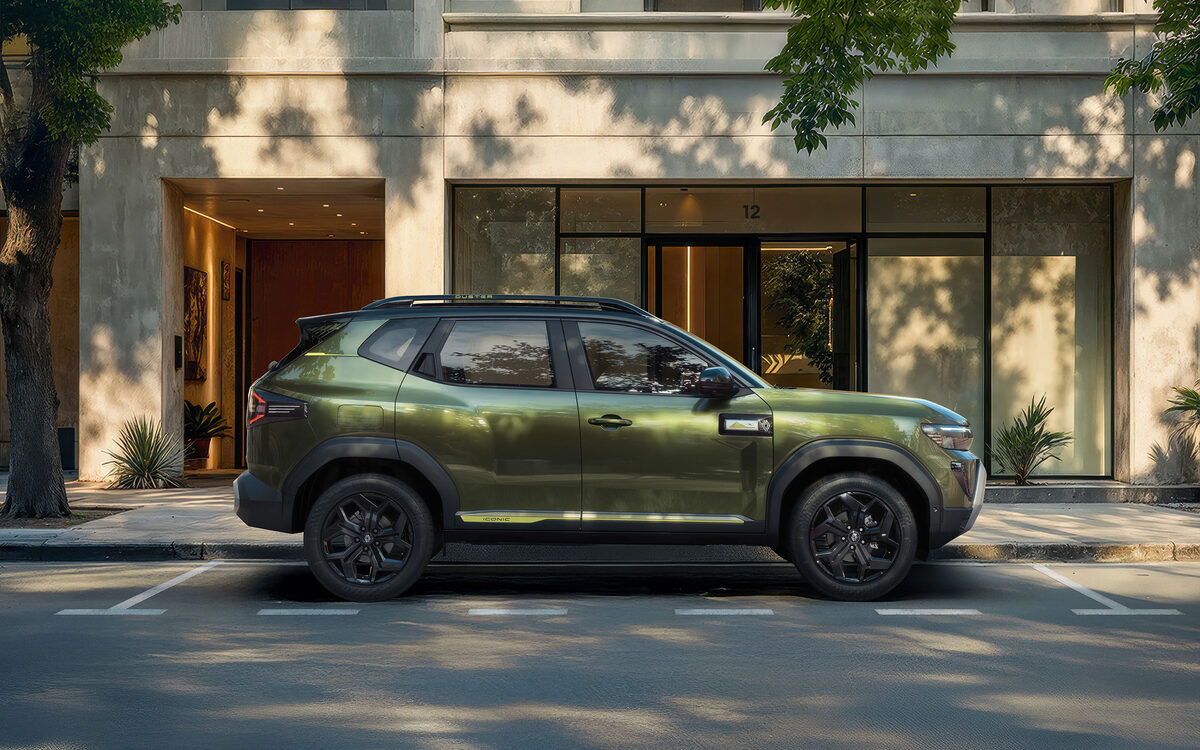Green Renault Duster in side profile parked outside a building