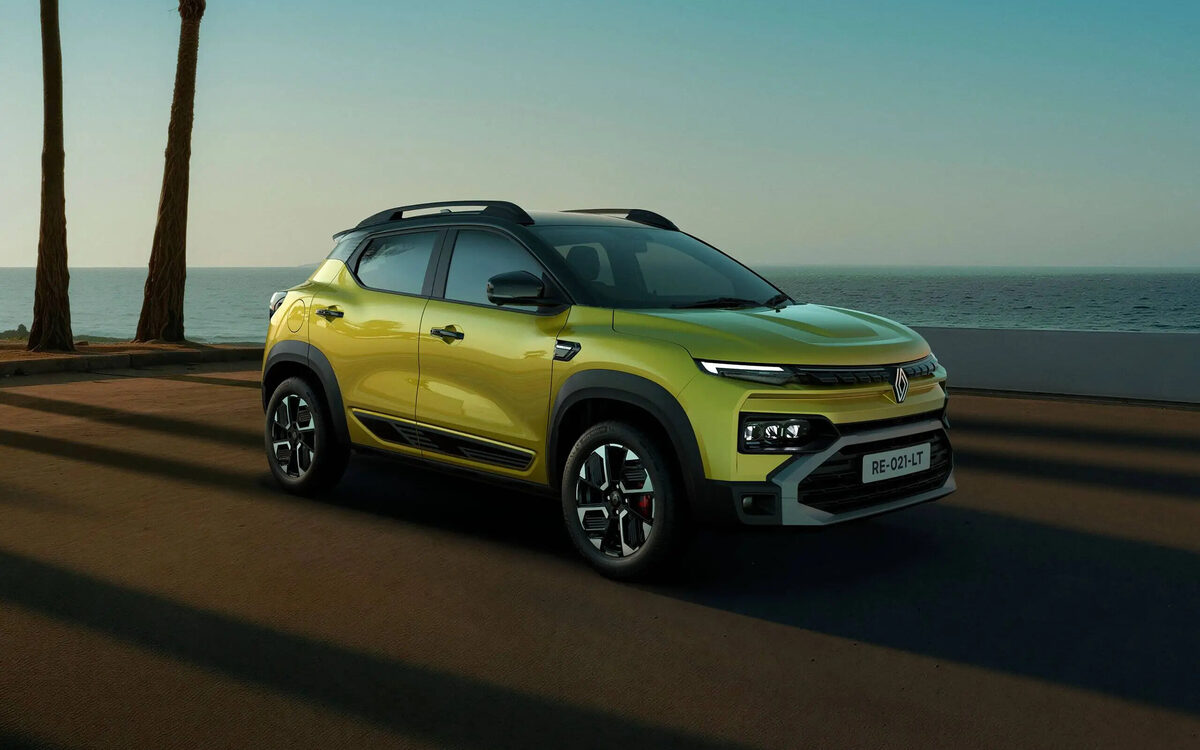 Renault Kiger in Oasis Yellow, front three-quarter view on a beach road at dusk