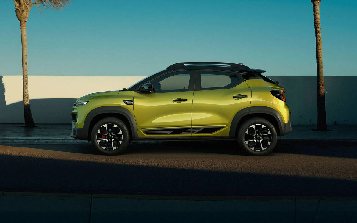 Renault Kiger in Oasis Yellow, side profile on a seaside road
