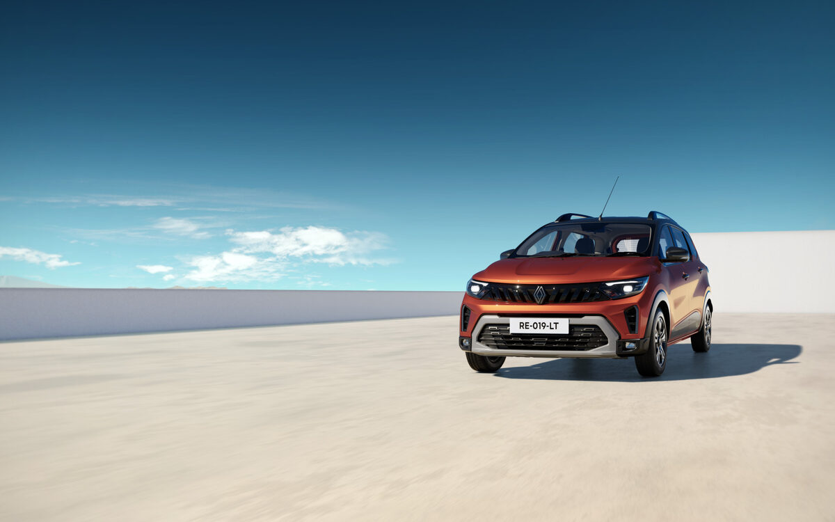 Orange Renault Triber facing the camera on a flat open plain under a blue sky