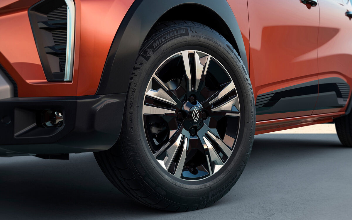 Close-up of the orange Triber front alloy wheel and wheel arch cladding