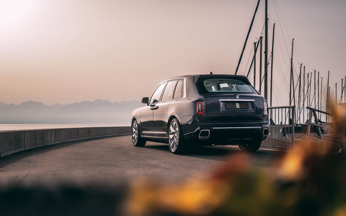 Rolls-Royce Cullinan rear three-quarter view on a waterfront road