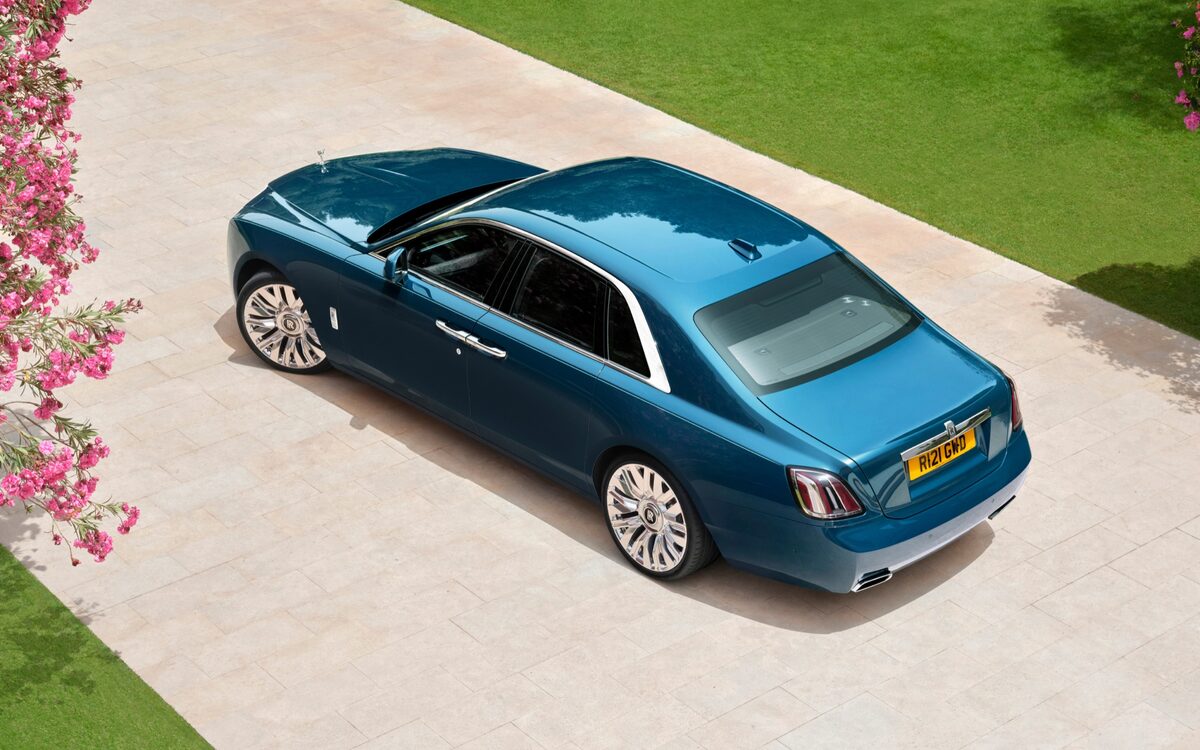 Rolls-Royce Ghost seen from above and behind on a paved drive with flowers