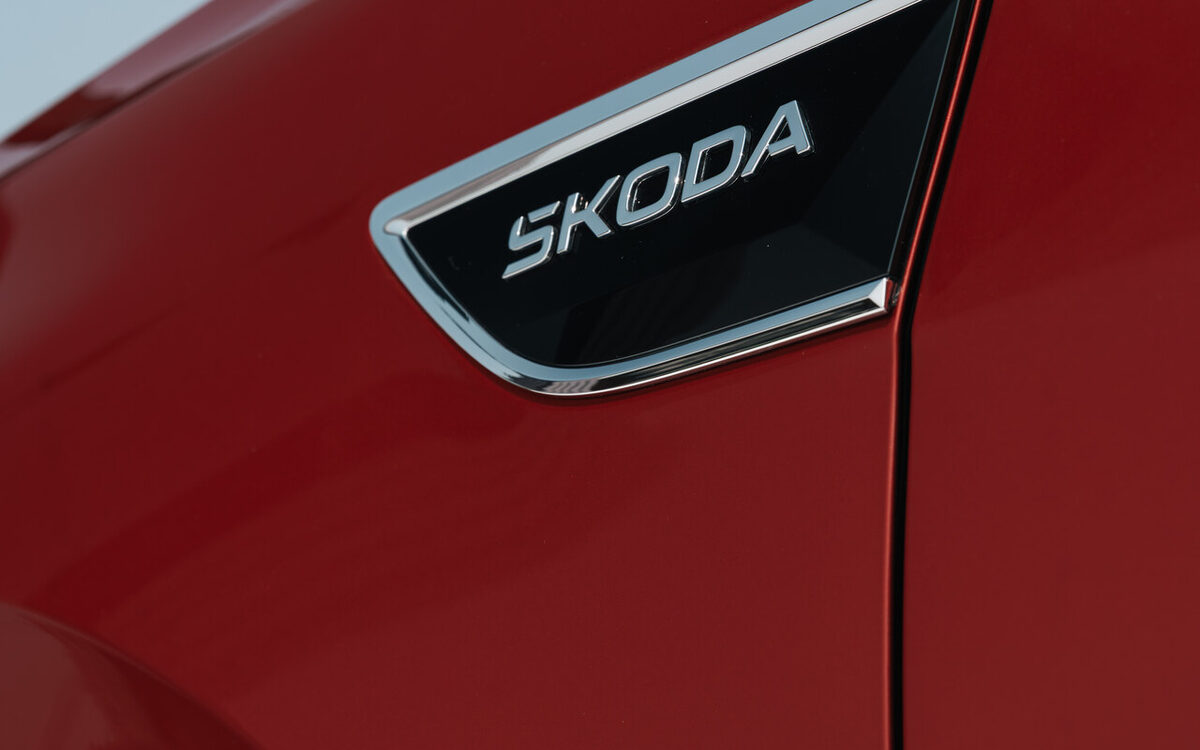 Close-up of the Skoda badge on the front fender of a red Kushaq
