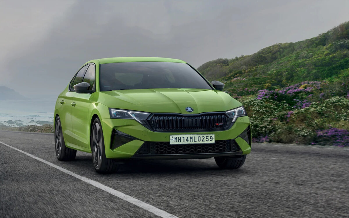 Skoda Octavia RS in Mamba Green driving towards the camera on a coastal road