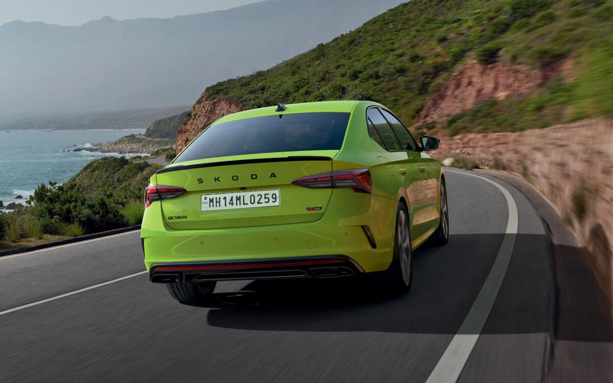 Skoda Octavia RS in Mamba Green seen from behind on a winding seaside road