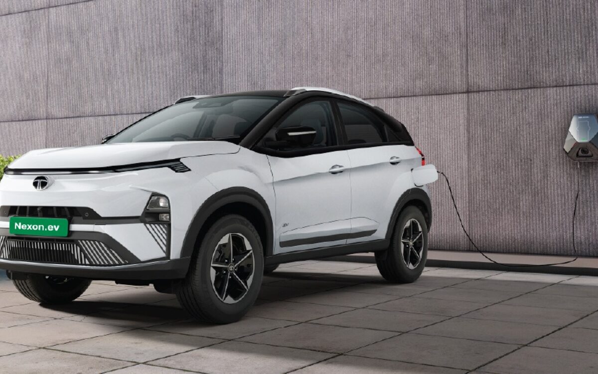 Tata Nexon.ev in white plugged into a wall charger in a garage