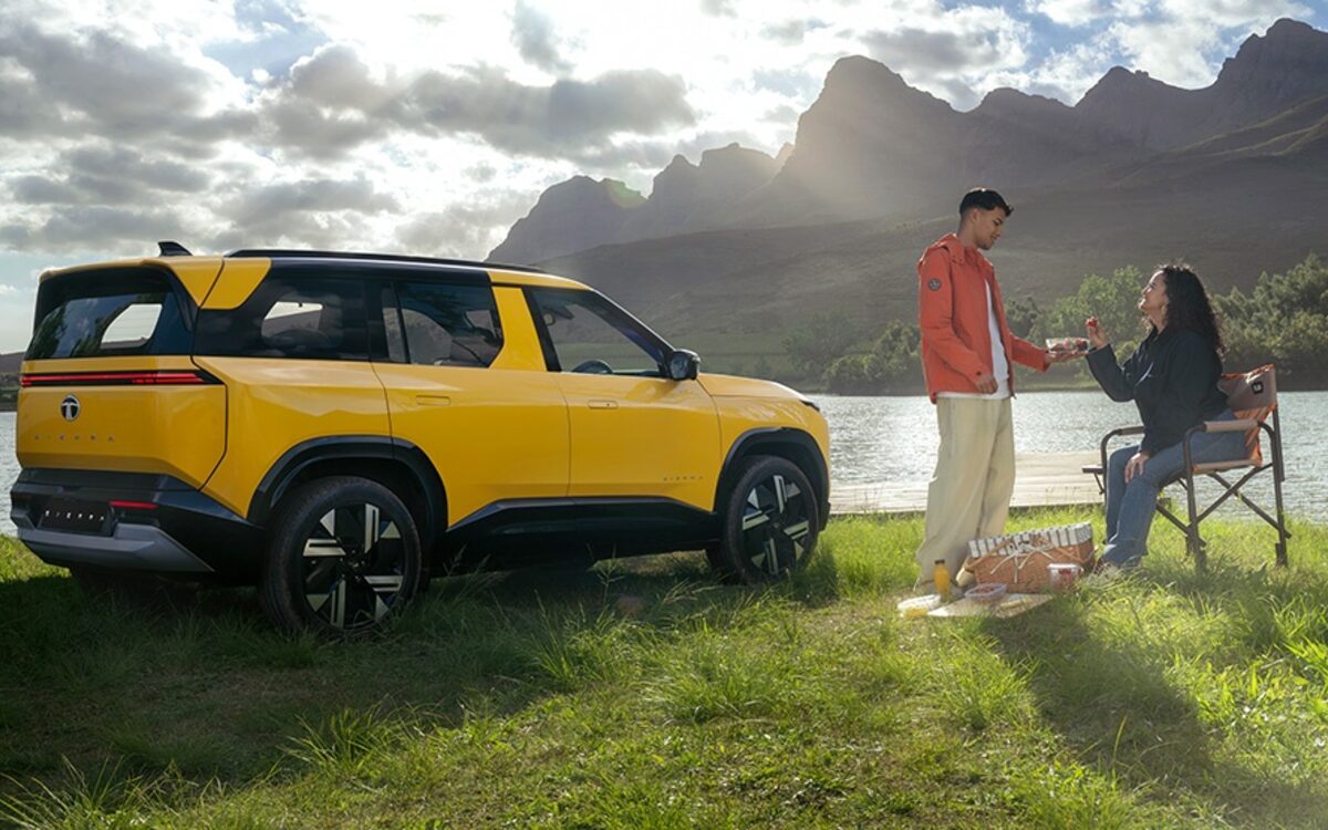 Tata Sierra in yellow parked by a mountain lake, rear three-quarter view