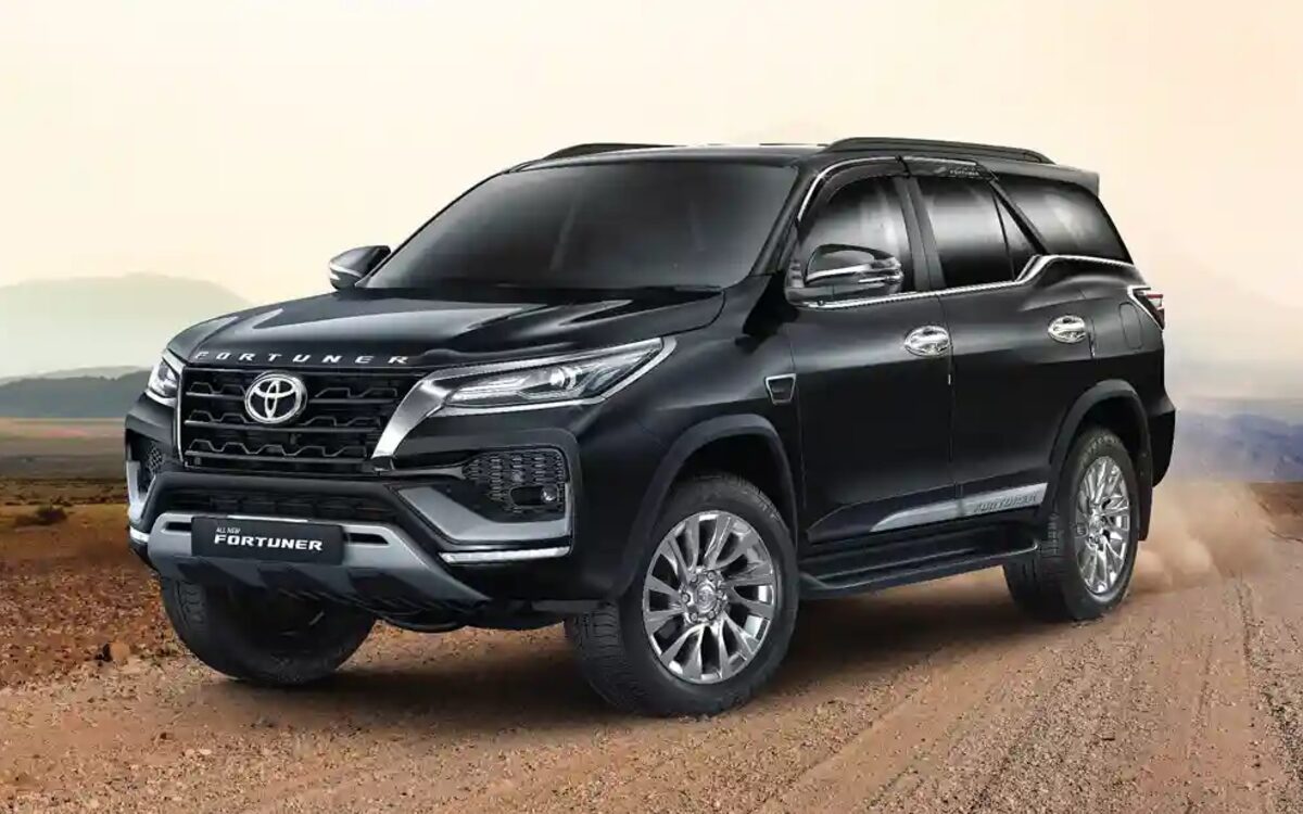 Black Toyota Fortuner on a dirt track in the desert, front three-quarter view