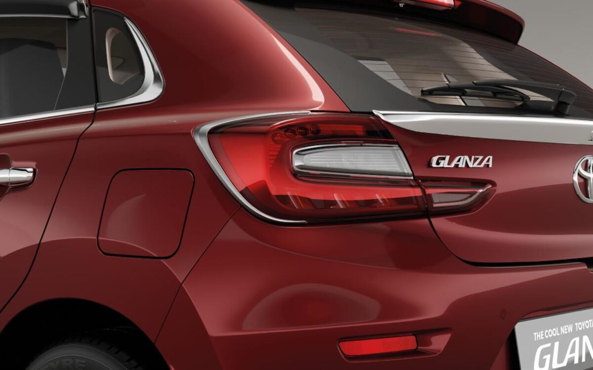 Rear three-quarter close view of a red Toyota Glanza with tail lamp and Glanza badge
