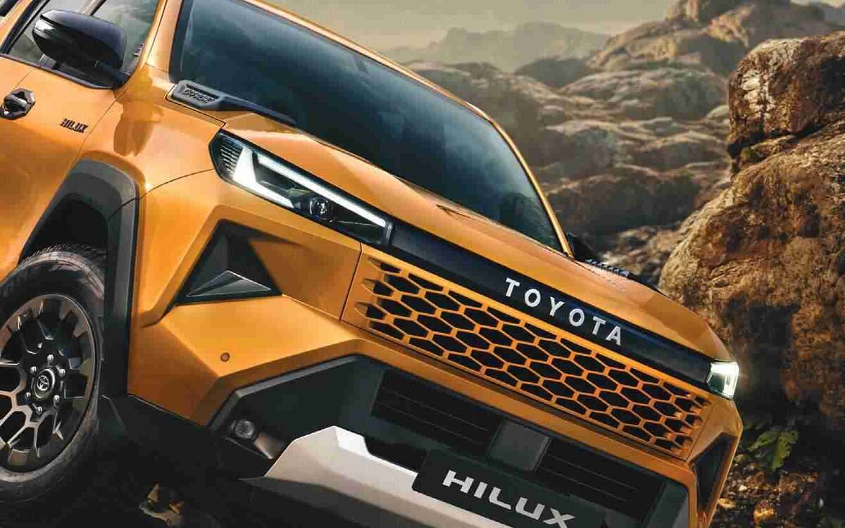 Toyota Hilux climbing over rocks in a mountain valley, front view