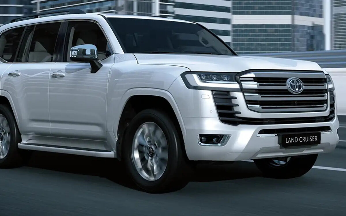Toyota Land Cruiser in white on a city flyover road, front three-quarter view
