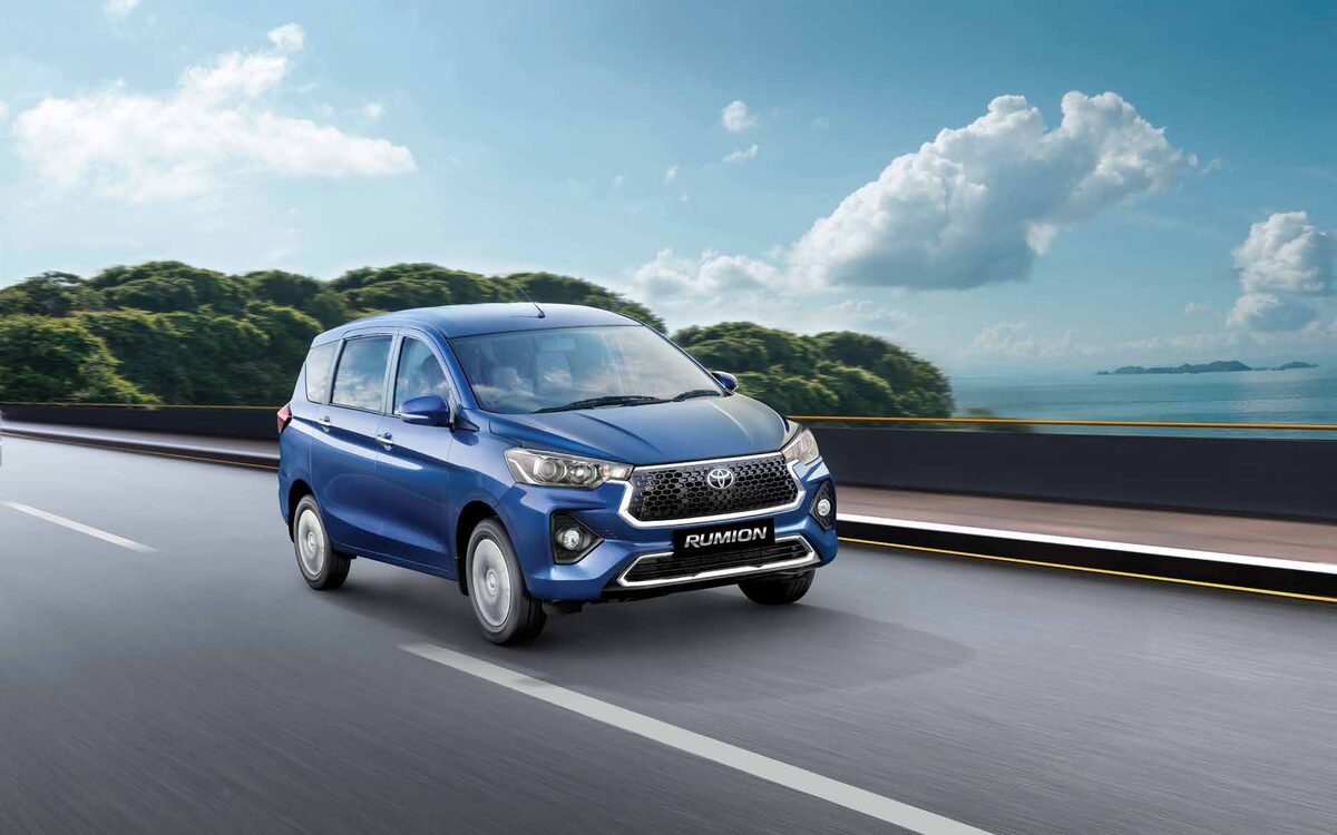 Blue Toyota Rumion driving along a coastal road, front three-quarter view