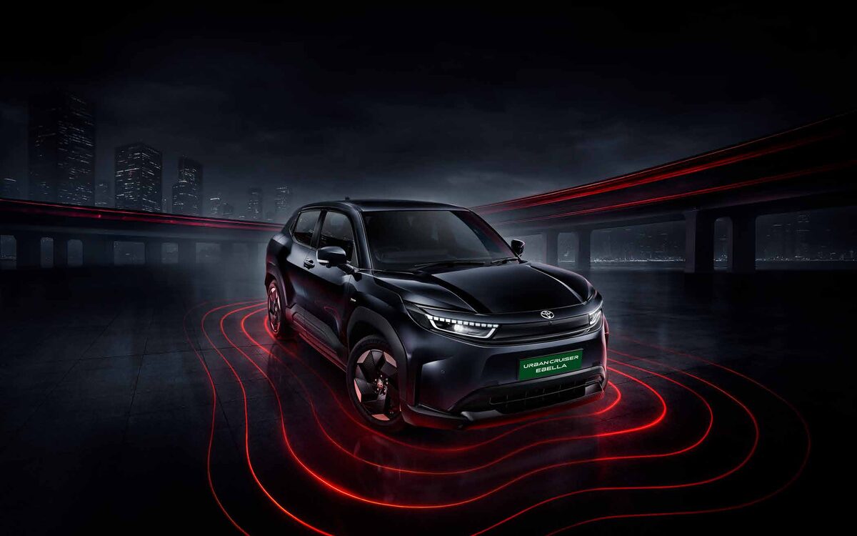 Toyota Urban Cruiser Ebella in black, front three-quarter view with red light trails on a road