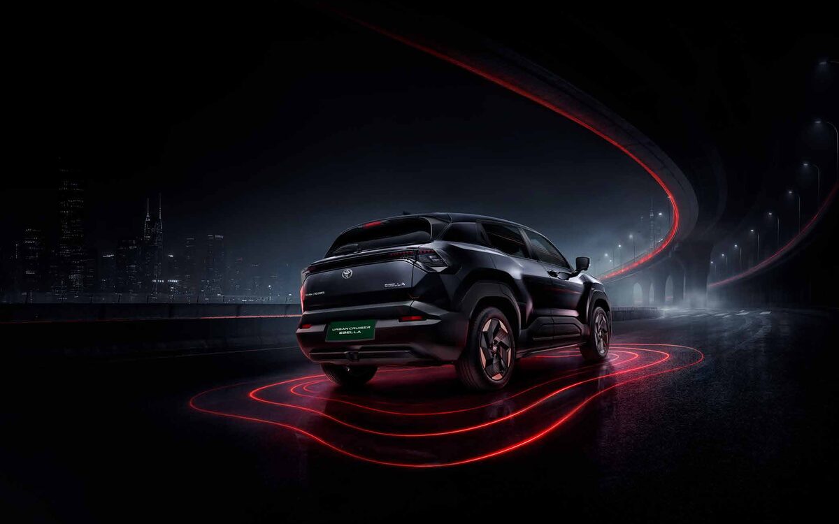 Toyota Urban Cruiser Ebella in black, rear three-quarter view at night with red light trails