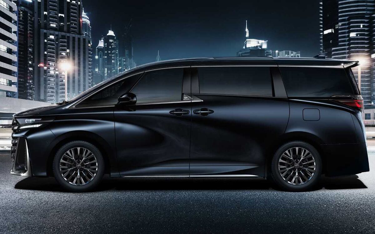 Toyota Vellfire in black, side profile in front of a city skyline at night