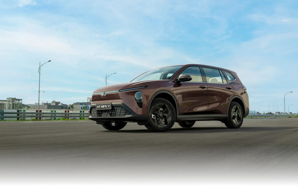 VinFast VF MPV 7 in Introspective Brown, front three-quarter view on a test road