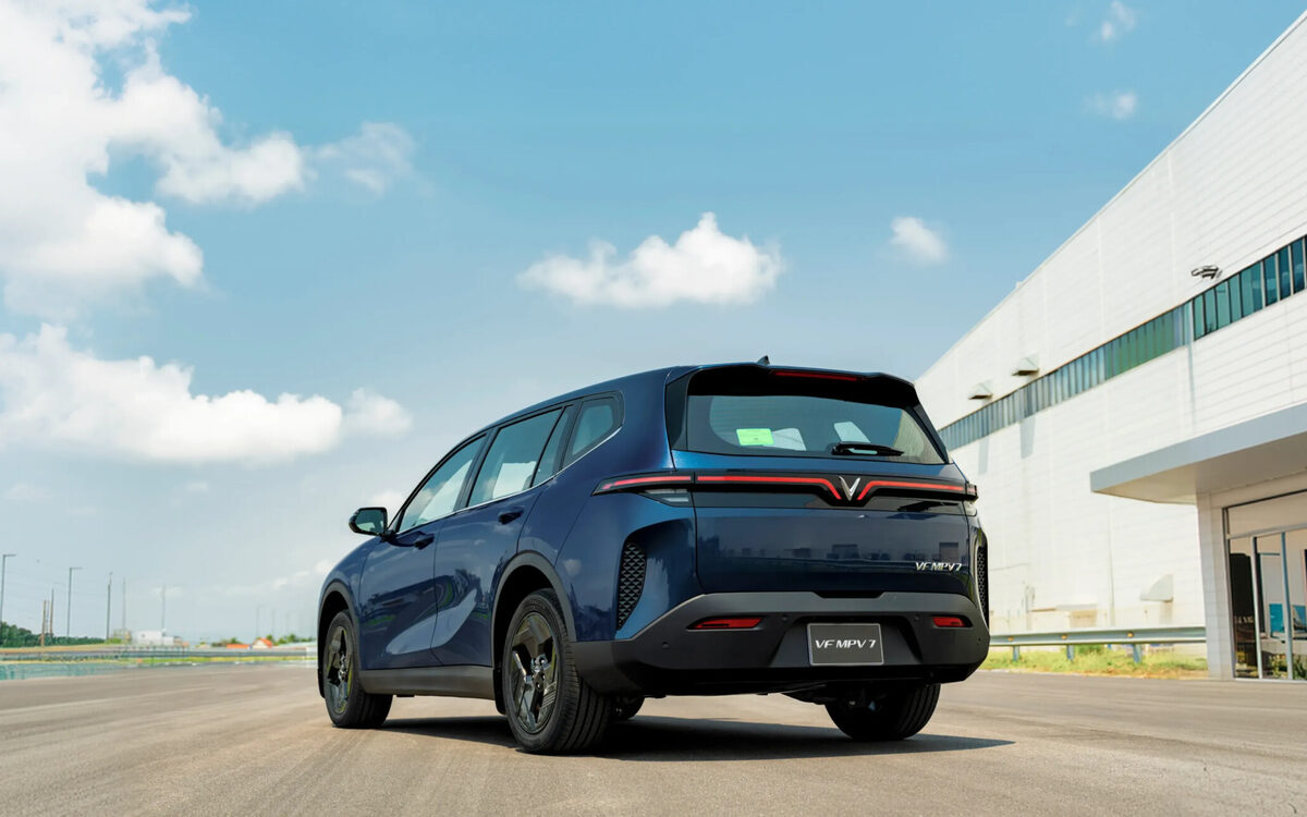 VinFast VF MPV 7 in blue, rear three-quarter view outside a building