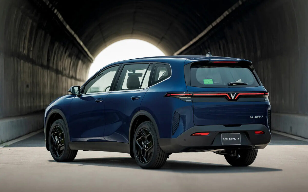 VinFast VF MPV 7 in blue, rear three-quarter view at a tunnel exit