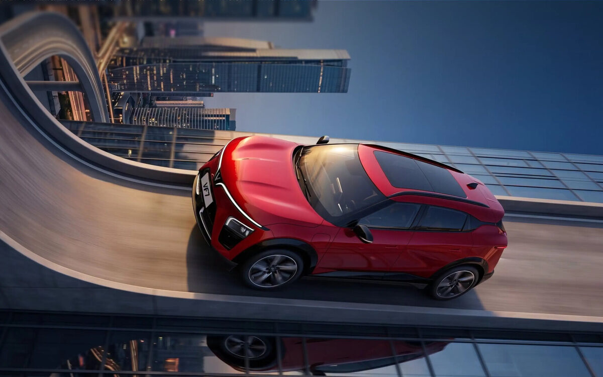 VinFast VF 7 in red seen from above on a curving elevated road