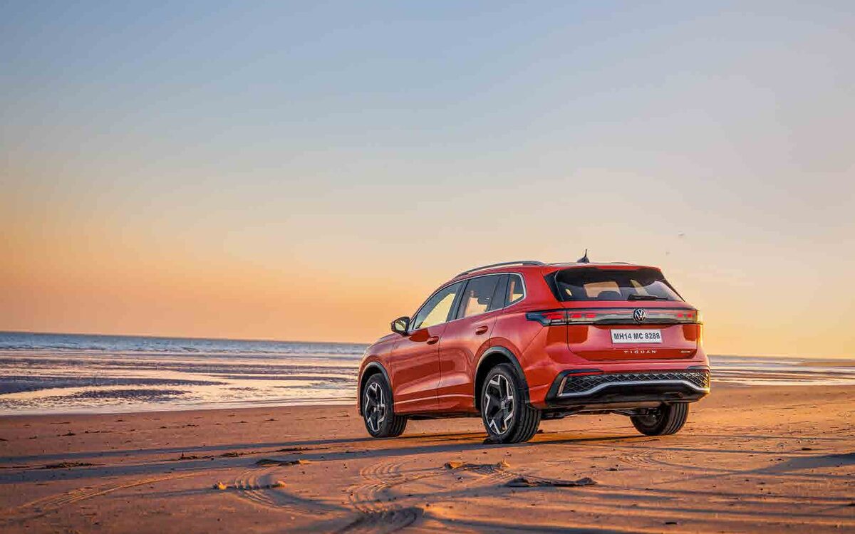 Tiguan R-Line in red, rear three-quarter view on a beach at sunset